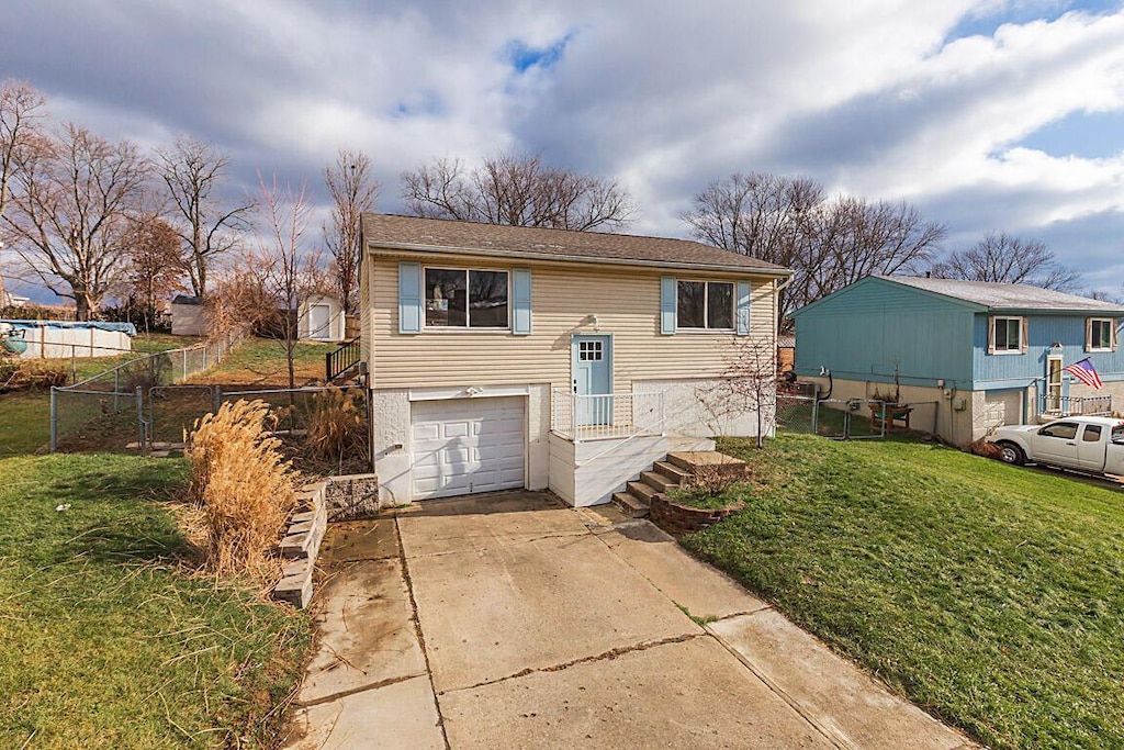 raised ranch featuring a garage and a front yard