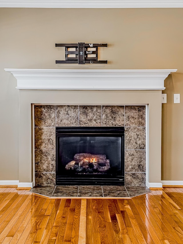 interior details with hardwood / wood-style flooring and a tiled fireplace