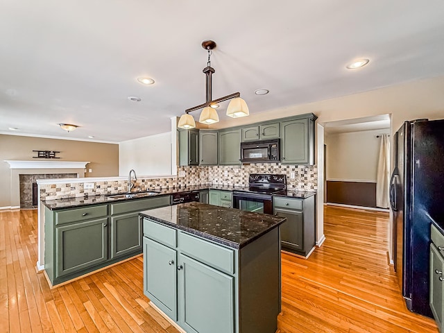 kitchen featuring black appliances, light hardwood / wood-style floors, sink, decorative light fixtures, and backsplash