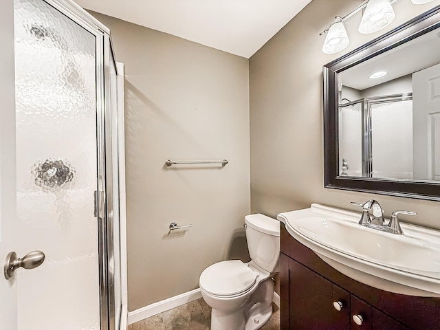 bathroom featuring an enclosed shower, vanity, and toilet