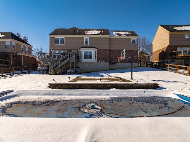 view of snow covered back of property