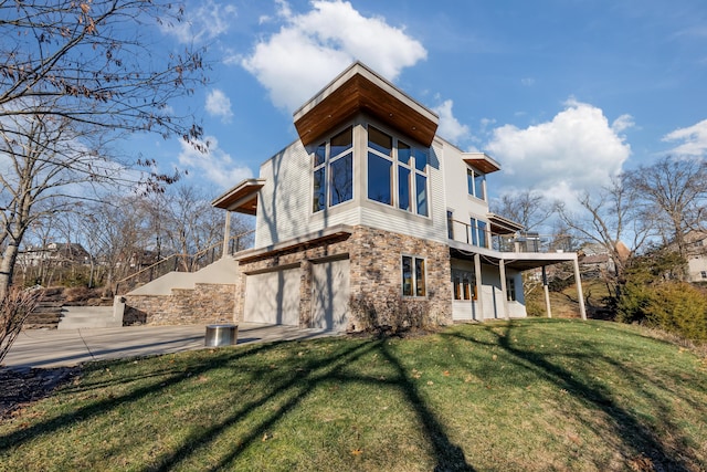 back of property with a yard, a balcony, and a garage