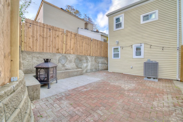 view of patio / terrace featuring central air condition unit and an outdoor fire pit