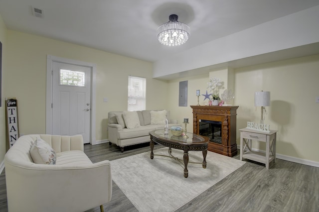 living room with dark wood-type flooring, electric panel, and a chandelier