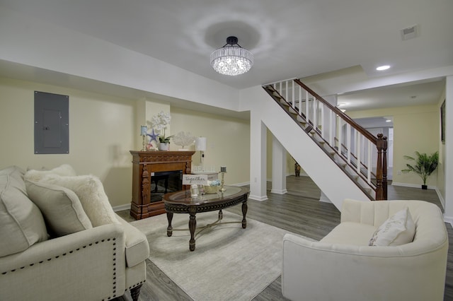 living room with electric panel, dark wood-type flooring, and an inviting chandelier