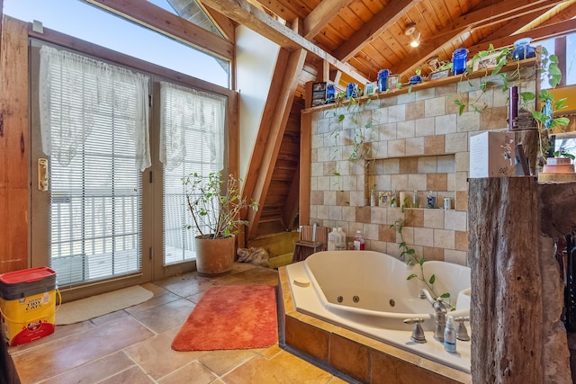 bathroom featuring vaulted ceiling with beams, wooden ceiling, and a tub with jets