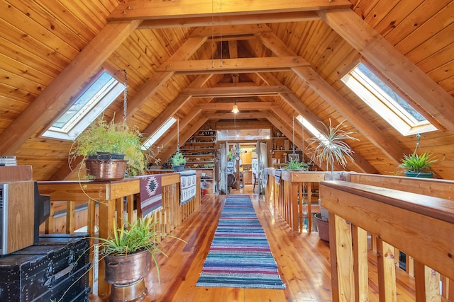 additional living space featuring vaulted ceiling with skylight, wood-type flooring, and wooden ceiling