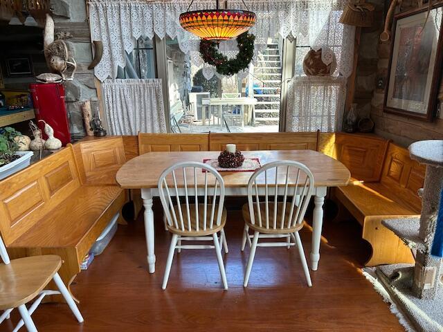 dining space with breakfast area and wood finished floors