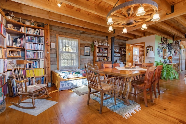 dining area featuring beamed ceiling, wooden ceiling, and hardwood / wood-style flooring