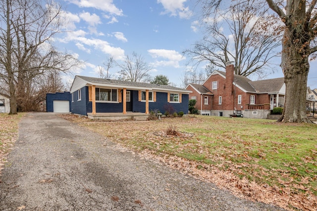 ranch-style house featuring an outbuilding, a front yard, and a garage