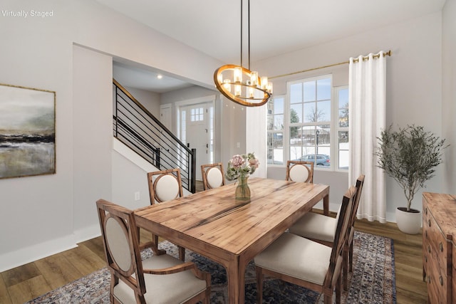 dining area with hardwood / wood-style floors and an inviting chandelier