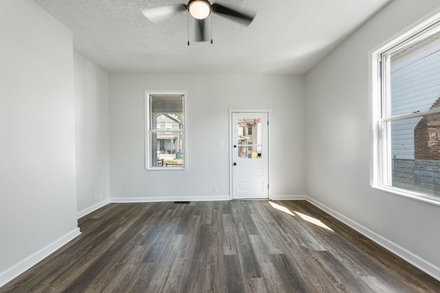 unfurnished room featuring ceiling fan, dark hardwood / wood-style flooring, and a textured ceiling