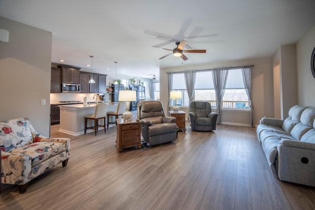 living room featuring light hardwood / wood-style floors and ceiling fan