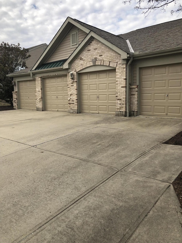 view of front of property with a garage, brick siding, and driveway