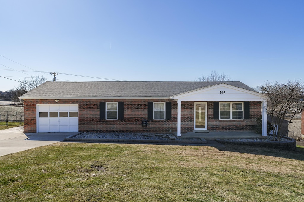 single story home featuring a garage and a front yard