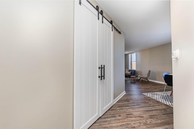 corridor featuring dark hardwood / wood-style flooring and a barn door