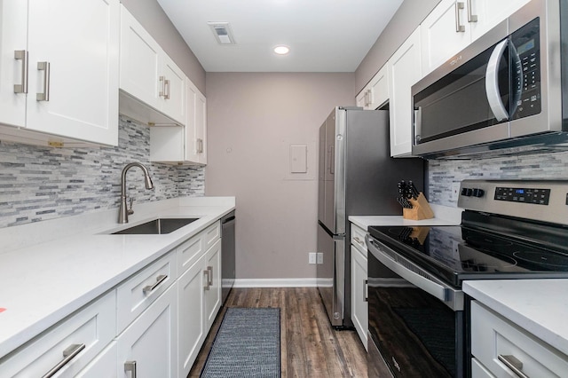 kitchen featuring dark hardwood / wood-style flooring, white cabinetry, sink, and appliances with stainless steel finishes