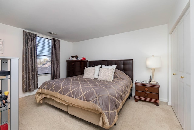 bedroom featuring light colored carpet and a closet