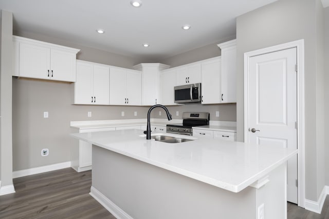 kitchen featuring white cabinetry, a kitchen island with sink, sink, and appliances with stainless steel finishes