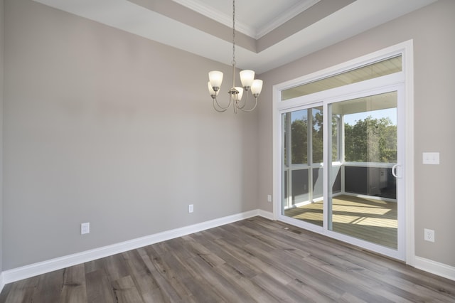 unfurnished room featuring a chandelier, hardwood / wood-style flooring, a raised ceiling, and crown molding