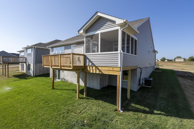 back of property featuring a yard, central air condition unit, a deck, and a sunroom