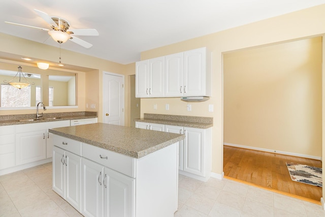 kitchen with a center island, sink, ceiling fan, light wood-type flooring, and white cabinetry