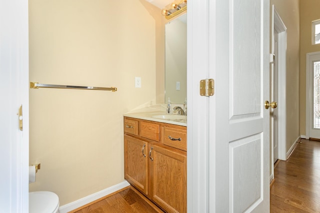 bathroom with vanity, hardwood / wood-style flooring, and toilet