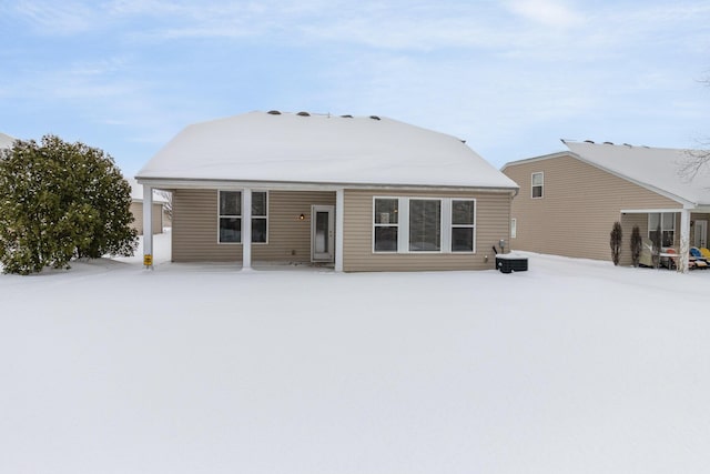 snow covered rear of property featuring central air condition unit