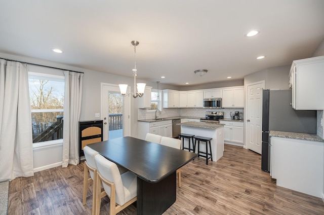 dining area with hardwood / wood-style flooring, an inviting chandelier, and sink