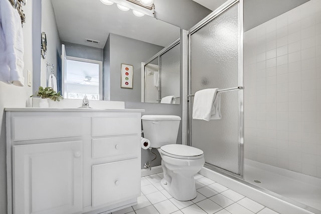 bathroom featuring tile patterned flooring, vanity, toilet, and walk in shower