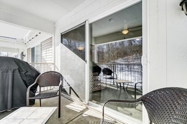 snow covered back of property featuring ceiling fan and grilling area