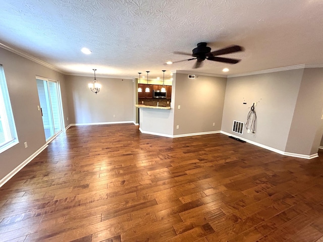 unfurnished living room with ceiling fan with notable chandelier, dark hardwood / wood-style flooring, and a textured ceiling