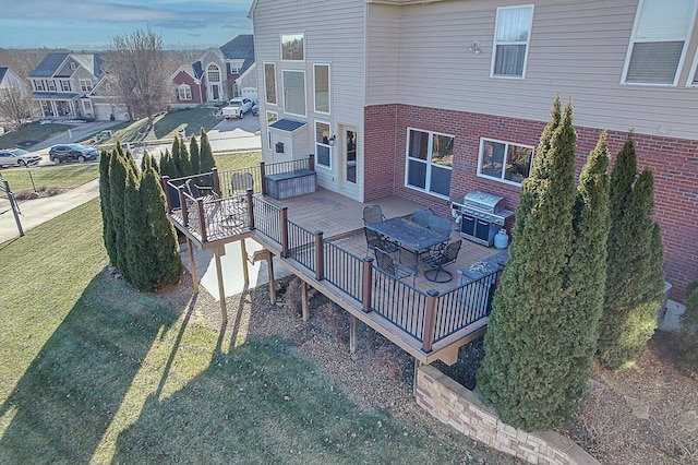 wooden deck featuring a grill and a lawn