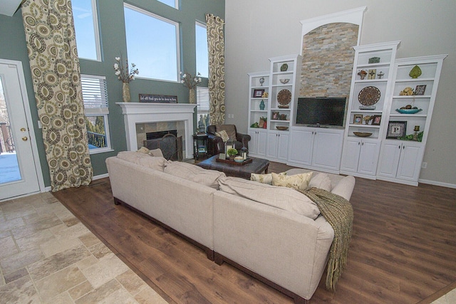 living room with a fireplace and a towering ceiling