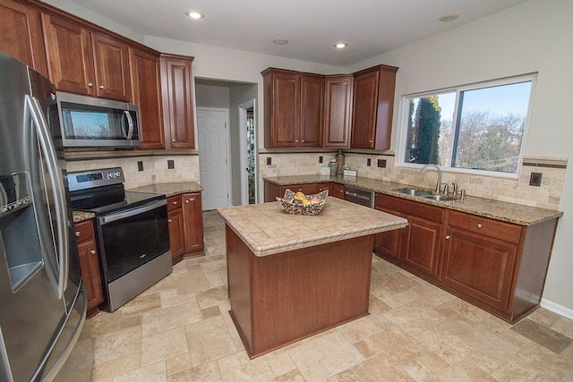 kitchen with stainless steel appliances, sink, tasteful backsplash, and a center island