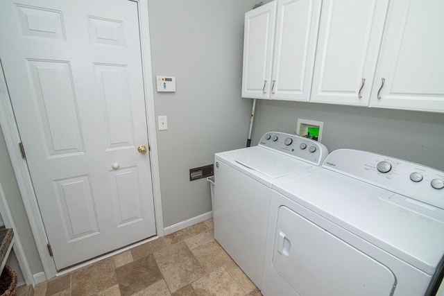 washroom with cabinets and washing machine and dryer