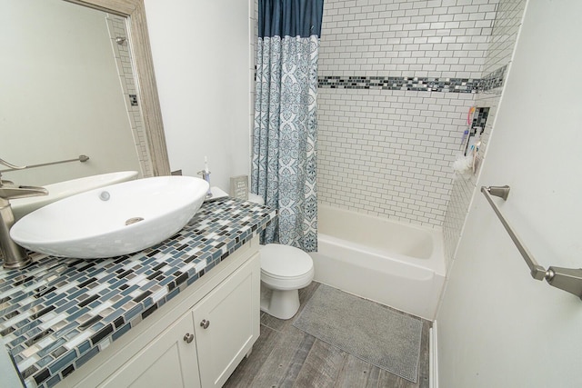 full bathroom featuring toilet, vanity, shower / bath combo with shower curtain, and hardwood / wood-style flooring