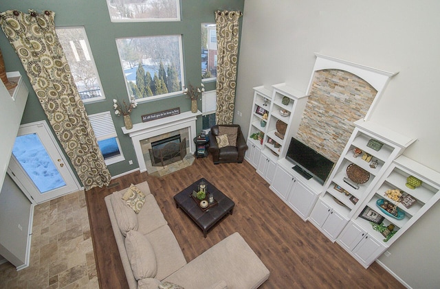 living room with a tile fireplace and a towering ceiling