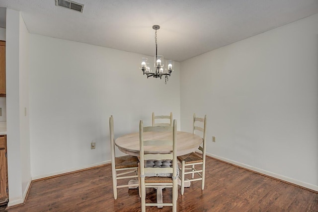 dining room featuring a chandelier and dark wood-type flooring