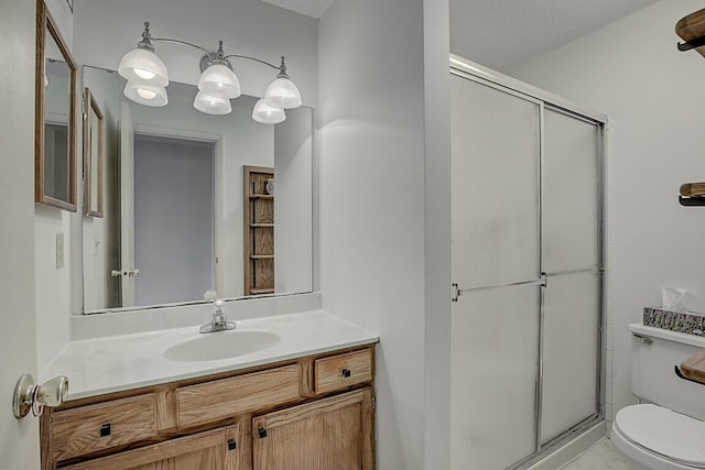 bathroom featuring vanity, toilet, and a shower with door