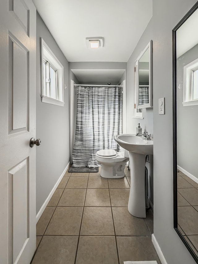 bathroom with tile patterned flooring, curtained shower, and toilet