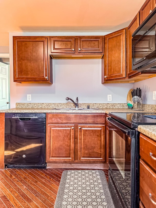 kitchen with sink, black appliances, and dark hardwood / wood-style floors