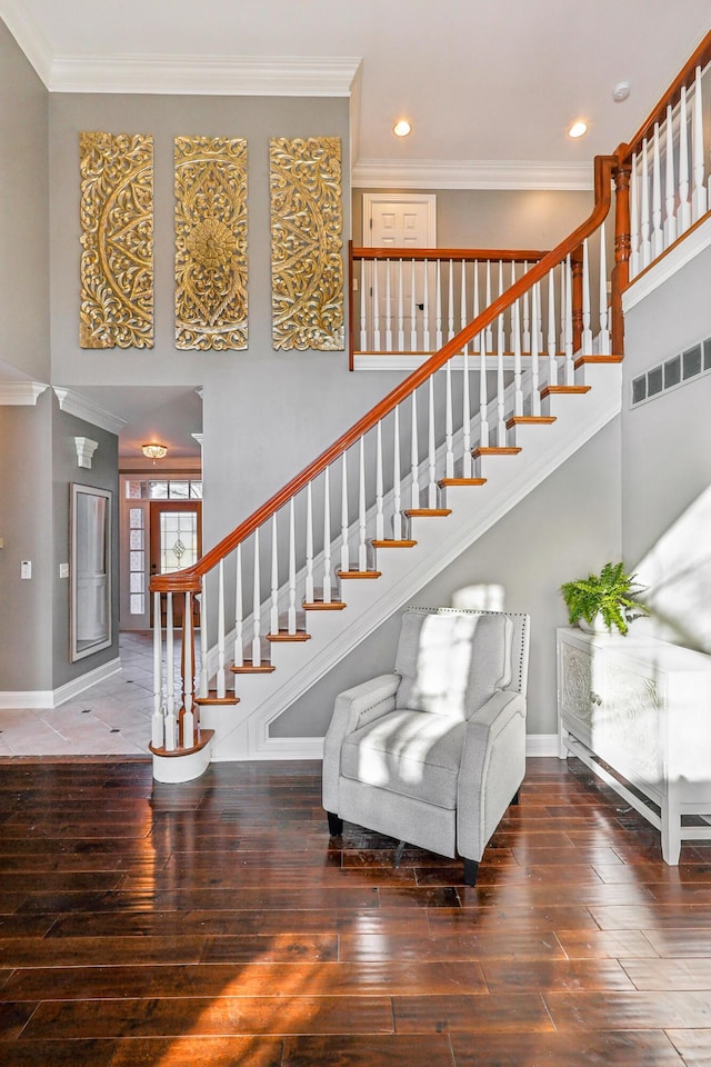 staircase with crown molding and hardwood / wood-style floors