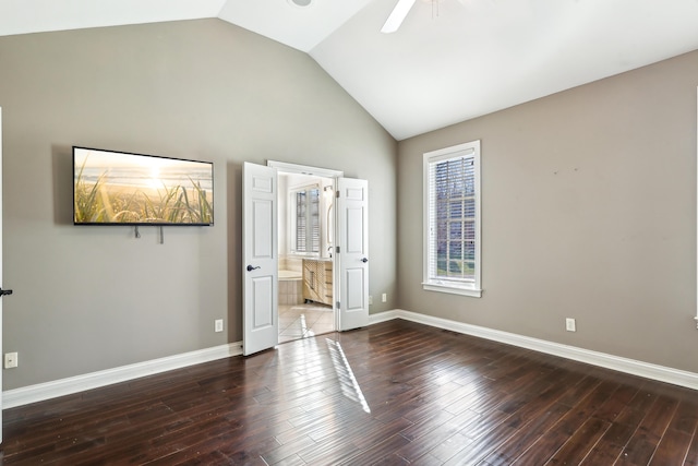 unfurnished bedroom featuring ceiling fan, dark wood-type flooring, connected bathroom, and lofted ceiling