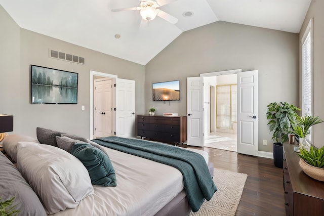 bedroom with ceiling fan, connected bathroom, dark hardwood / wood-style flooring, and vaulted ceiling