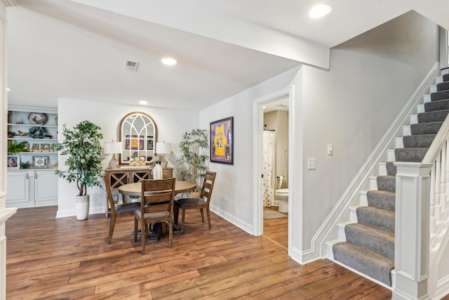 dining space featuring built in shelves and wood-type flooring