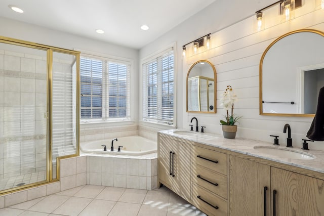 bathroom with tile patterned floors, vanity, and shower with separate bathtub