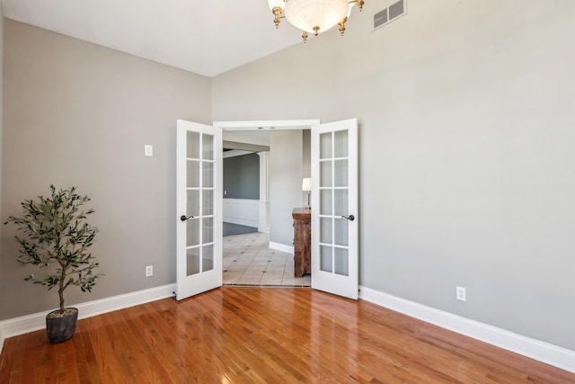 spare room with french doors and hardwood / wood-style floors