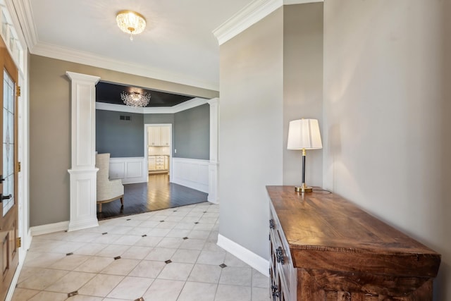 entrance foyer featuring ornate columns, light tile patterned flooring, and crown molding