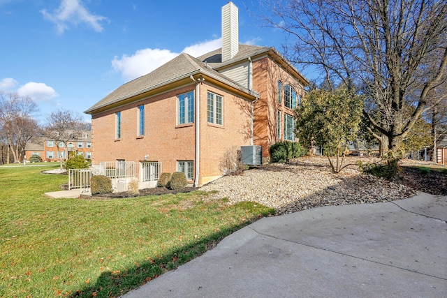 view of home's exterior featuring central AC and a yard